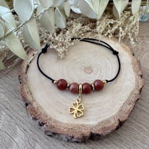 Bracelet ALYA Signature en jaspe rouge avec 4 perles 6 mm et pampille trèfle dorée sur cordon noir ajustable