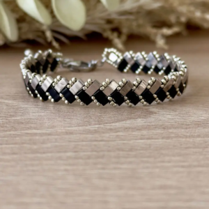 Bracelet Half Tila tissé noir argenté motif chevrons vue de face sur fond bois