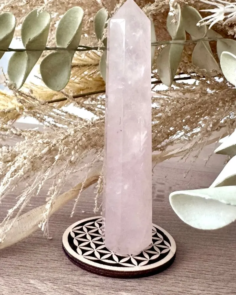 Pointe en quartz rose, pierre naturelle polie présentée sur support fleur de vie