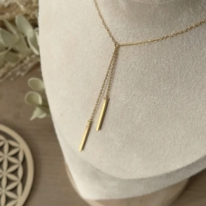 collier Double You doré en acier inoxydable femme – vue d’ensemble sur présentoir - ambiance chaleureuse
