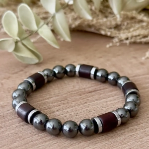 Bracelet homme Hématite & Bois associant l'éclat métallique de l'hématite, le bois naturel et l'acier inoxydable.