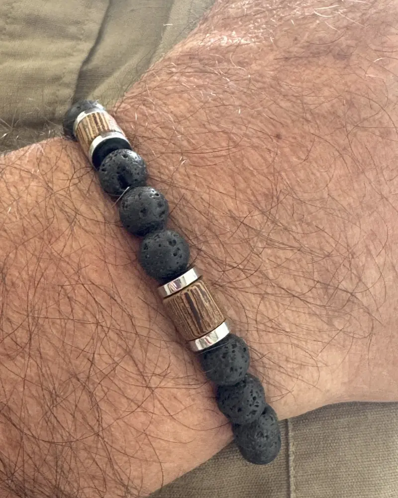 Bracelet homme Bois & Pierre en pierre de lave naturelle porté au poignet, associant bois naturel et acier inoxydable pour un style masculin et authentique.