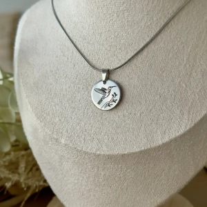 Collier Colibri argenté en acier inoxydable avec médaille gravée représentant un colibri.